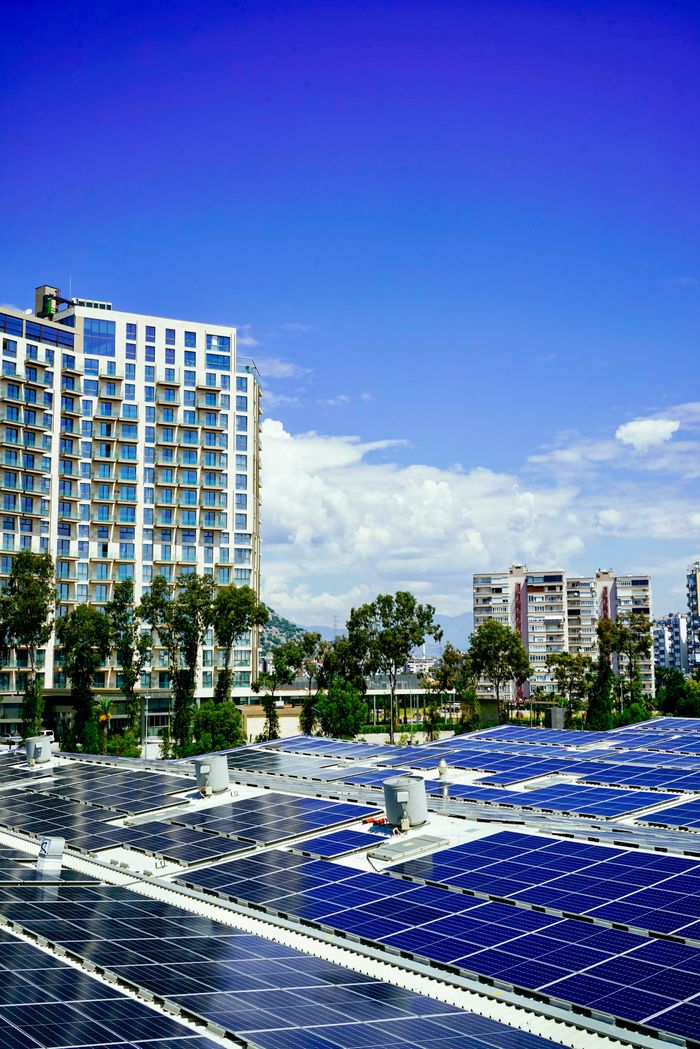 High-rise buildings and a large solar panel array under a clear blue sky.